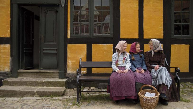 Piger på en bænk i 1864 i Den Gamle By i Aarhus