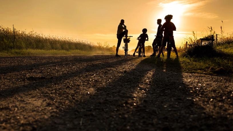 Familie im Radurlaub bei Sonnenuntergang in Dänemark